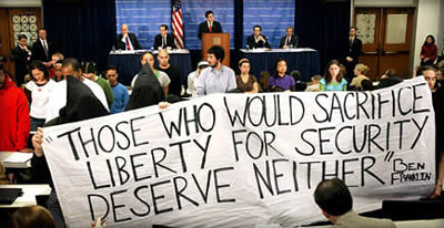 photo of protesters with banner that reads: those who would sacrifice liberty for security deserve neither